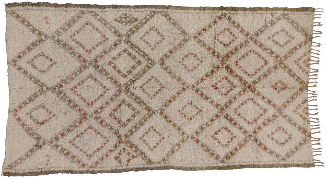 With its well defined lines and subtle hints of henna accents, this Berber Moroccan rug is believed to protect the human spirit from negative energy and shield the human body from the elements. Beni Ouarain (Beni Ourain) rugs are prized for their