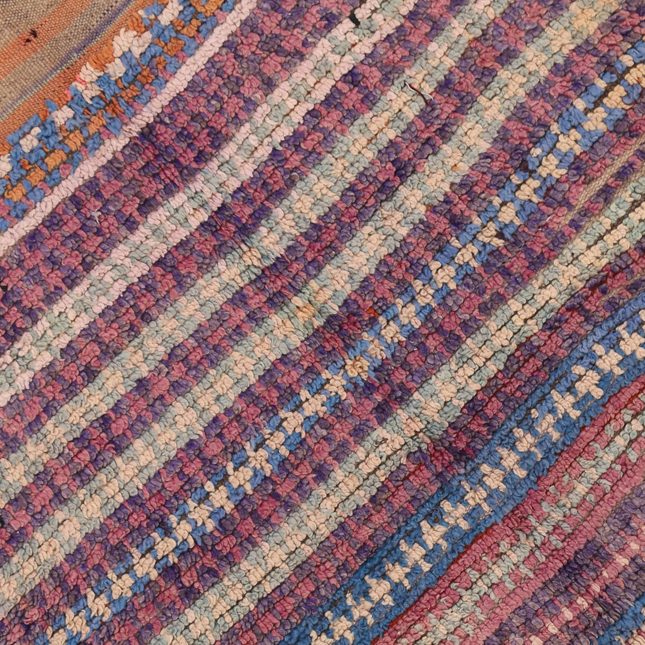 Moroccan carpets can transform a plain space into a lively interior. This delightful Moroccan rug showcases a delicate palette of pastels in narrow horizontal stripes. The lack of static designs in this vintage Moroccan gives it a free and