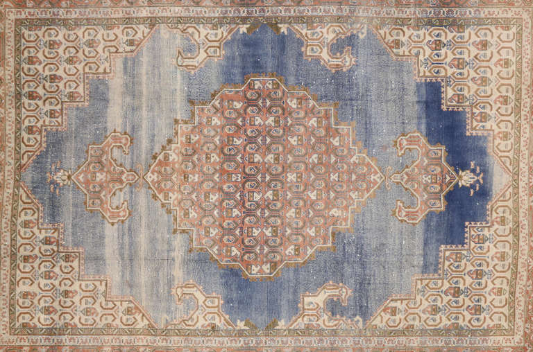 This beautiful antique Persian Arak has a center medallion with hues of salmon, blue, brown, and beige. This piece has an exquisite border that really showcases the details and beauty of this piece.