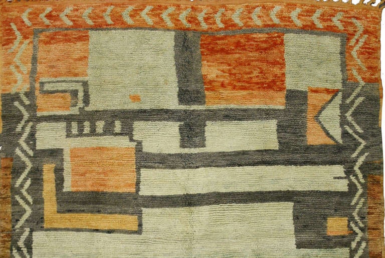 This Mid-Century Modern rug from Morocco is notable for its abstract, primitively contemporary square design which is wonderfully unique with a Mad Men vibe. A palette of orange, grey, seafoam green and hues of brown balance each other and create a