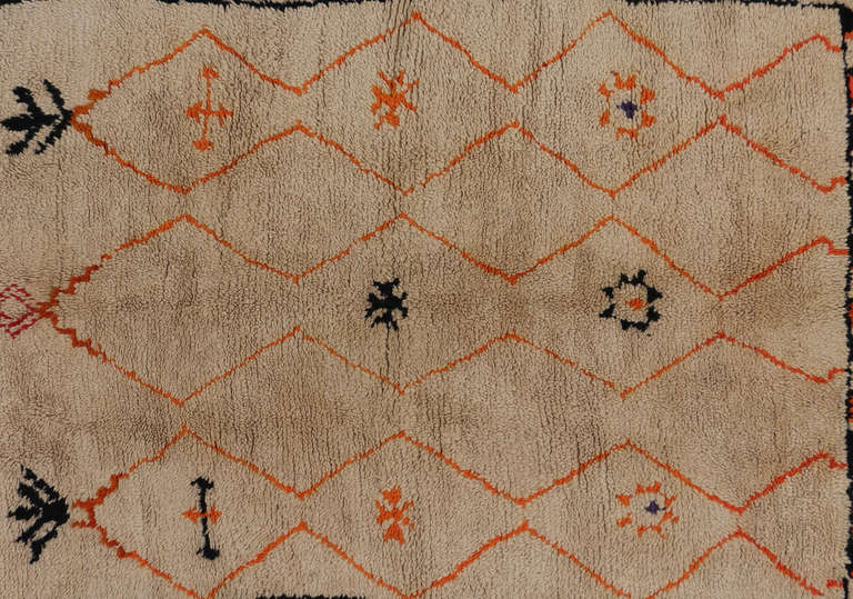 This unique Moroccan rug has a geometric latticework that creates a modern and abstract look. This piece has splashes of black, orange, and red that give this Moroccan piece its eclectic modern look. These Moroccan rugs are 100 percent wool, meaning
