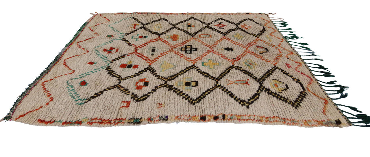 Add a tribal touch to your home with this vintage Moroccan rug. This carpet was handmade with sheep’s wool by the women of the Azilal province in the High Atlas Mountains of Morocco. With their plush pile and dense construction, these rugs were made