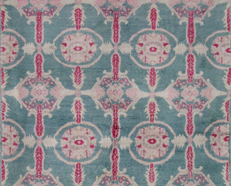 This colorful antique Indian Agra with cotton pile has an all over pattern and hues of teal, magenta, and beige.