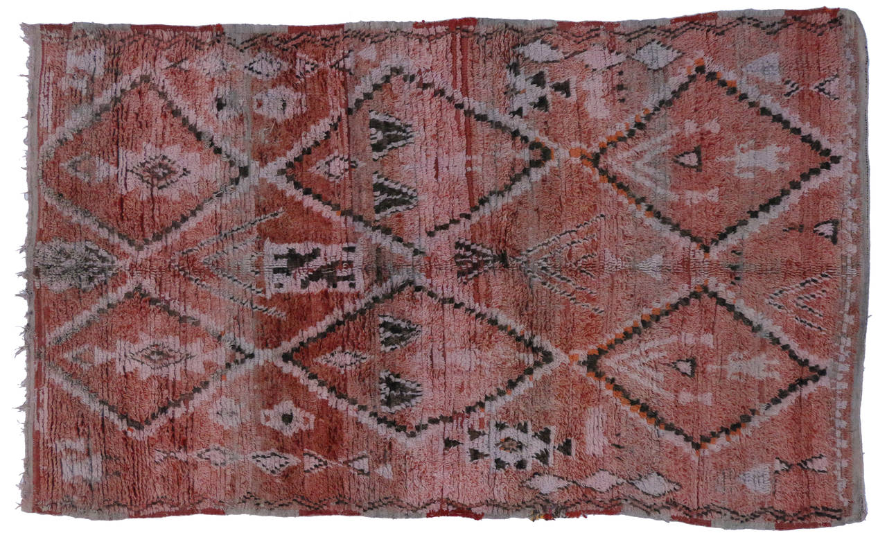 Showcasing hues of pantone’s spring color, Marsala, this vintage Moroccan rug is a one of a kind piece. Two rows of stacked diamonds equally balanced enclose symmetrical tribal motifs while creating two center diamonds that reflect secondary