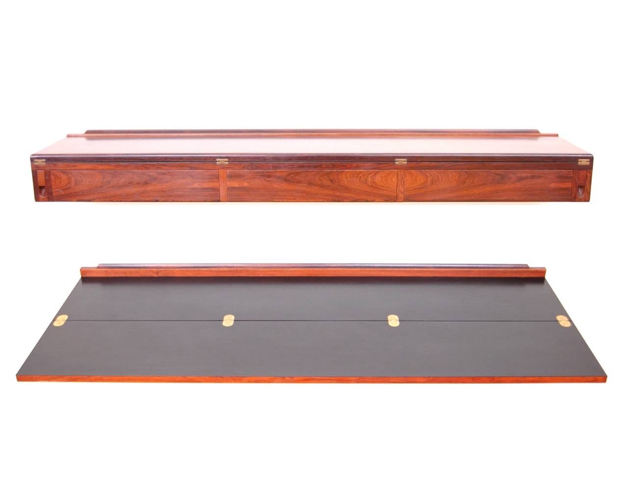 Ingenious wall-mounted desk console in rosewood by Arne Hovmand-Olsen. Console top flips open to reveal a 22 1/2