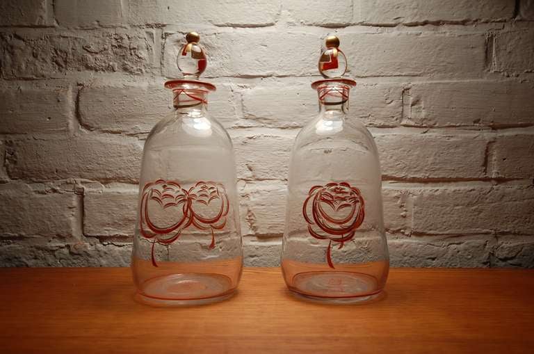 Rare pair of enameled glass bottles by Jean Luce (1895-1965), circa 1925. Hand blown glass, with polished pontil. Hand enameled with flower motif in red and gold. Each piece signed on pontil with Luce's 