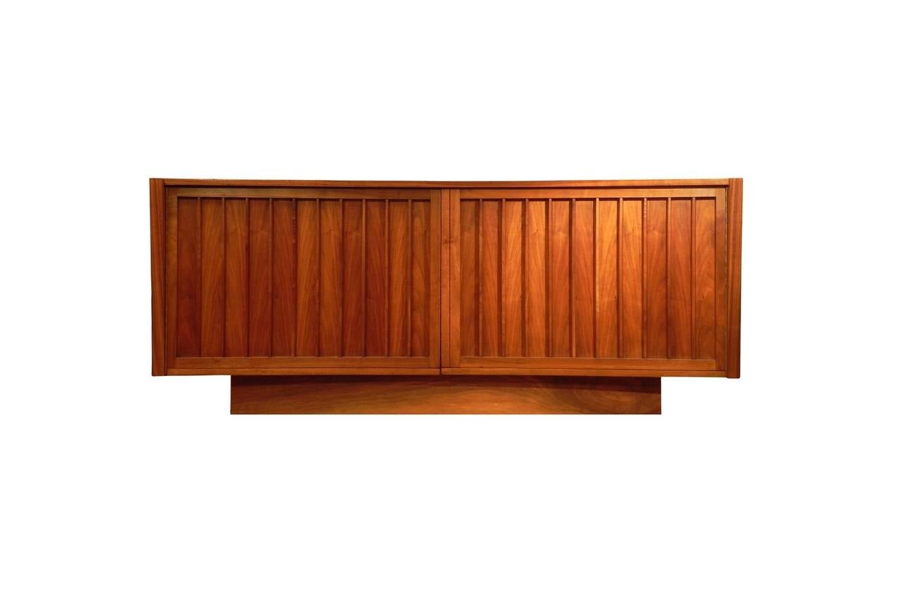 Walnut cabinet designed by George Nakashima, and produced by Widdicomb, circa 1959. Cabinet has two doors that open to reveal three center drawers, flanked by two storage areas with adjustable or removable shelves. Fully signed with Nakashima's