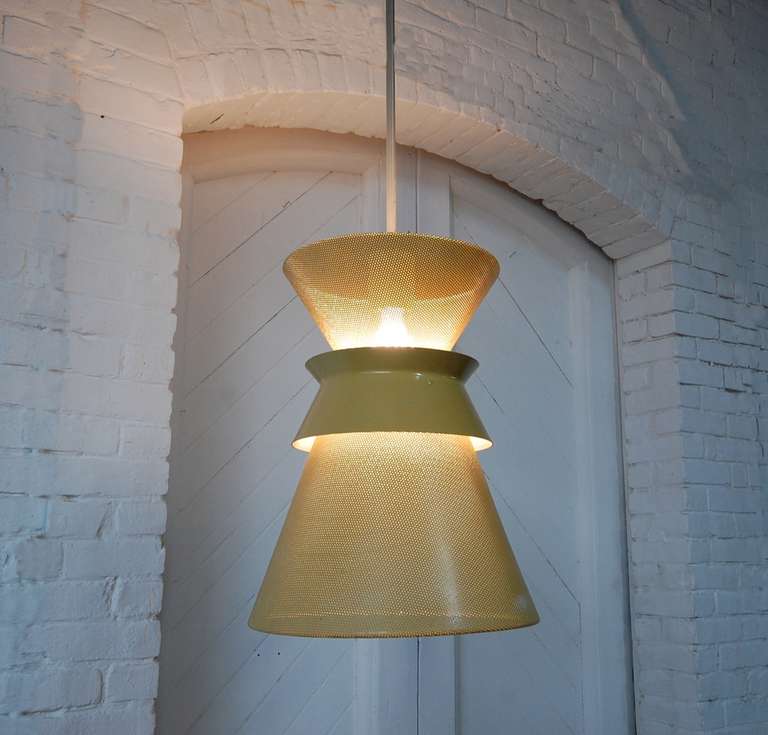 Perforated double cone pendant designed by Gerald Thurston, circa late 1950s for Lightolier. Lighting fixture is currently in it's original ochre with white interior, but we can have the color(s) changed for an additional charge if client so