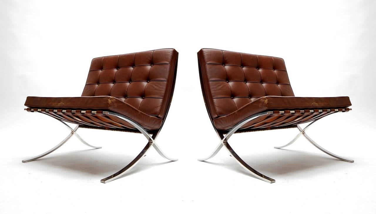 Pair of Barcelona lounge chairs in polished stainless steel and brown leather, designed by Mies van der Rohe, circa 1928. This pair, produced by Knoll Associates in December of 1968. Triple signed with two Knoll Associates tags, as well as stamped