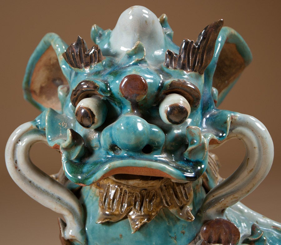 A pair of foo dogs in teal / light blue-green and with brown highlights.