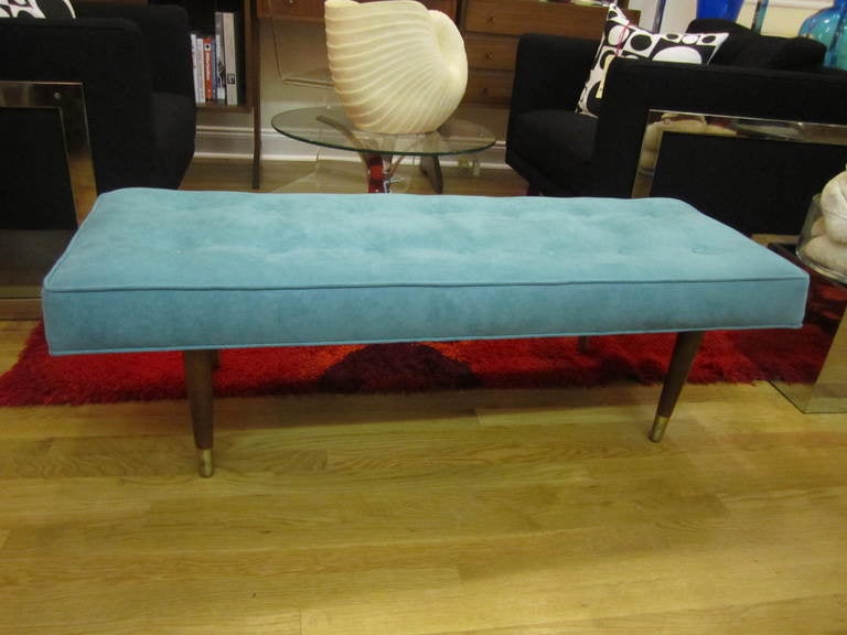 FABULOUS MILO BAUGHMAN TUFTED TURQUOISE ULTRA SUEDE BENCH.  RICH HIGH GRADE TURQUOISE ULTRA SUEDE WAS  USED TO REUPHOLSTER THIS WONDERFUL  MID-CENTURY MODERN BENCH.  THE WALNUT LEGS ARE CAPPED WITH BRASS SABOTS. THIS SWEET BENCH IS READY TO GO INTO