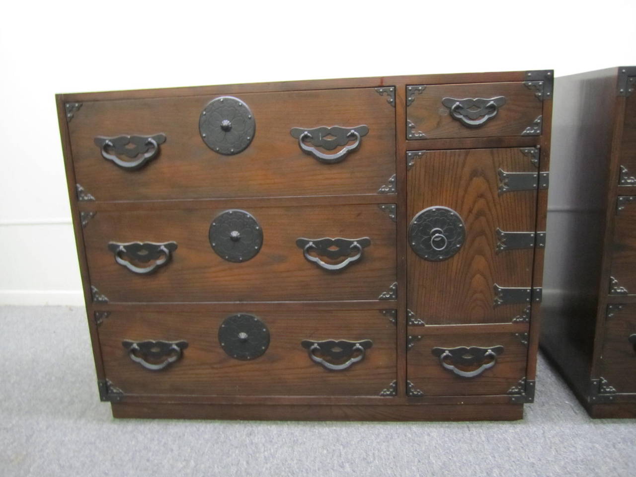 Pair of amazingly beautiful Japanese Tansu chests or cabinets by Baker.  Dark stained oak with fantastic Japanese inspired hardware. They have a time worn patina with splendid charm.  I love the vintage look of these- gives your interior real