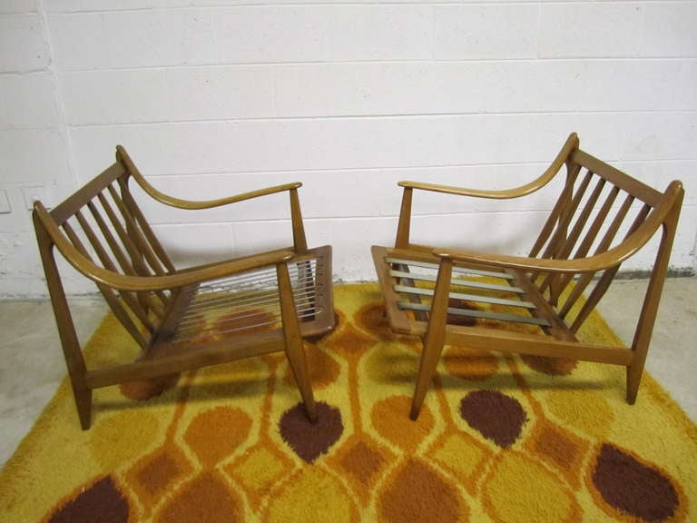 Super pair of 50's Danish modern light walnut swoop arm lounge chairs.  This pair is what i like to call decorator delights-just waiting for your fabulous touch.  The frames have a great vintage patina-ready for your new cushions.