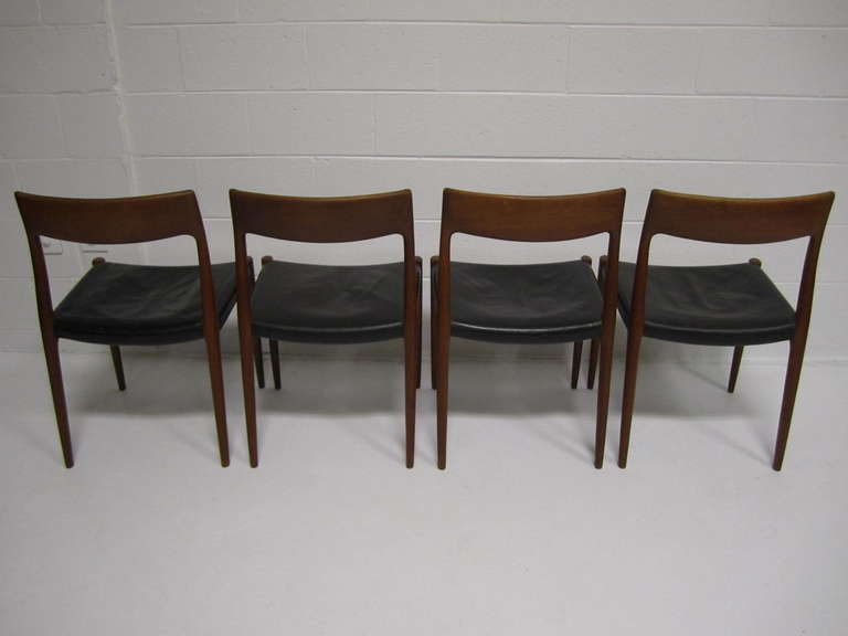 Lovely set of 4 signed J L Moller danish modern teak dining chairs.  The original leather seats are in vintage condition with minor wear.  The teak has a time worn honey brown patina and the frames are tight and sturdy.  Their are several labels