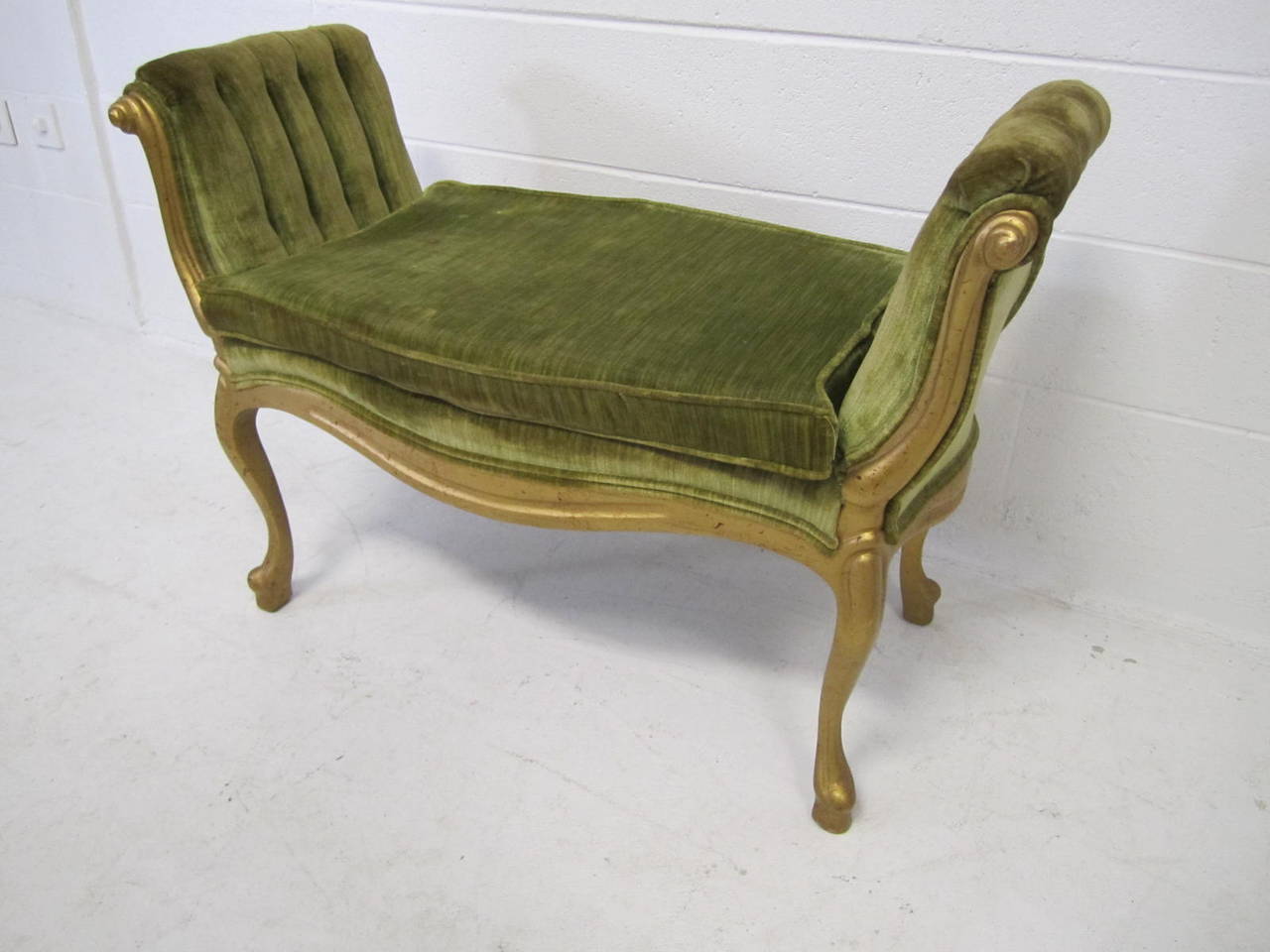 Lovely little hollywood regency style gold cabriolet leg bench.  This piece was reupholstered in the 70's with a green cotton velvet and still looks very nice.  Would be amazing in something new and fresh.  The painted gold carved wooden frame looks