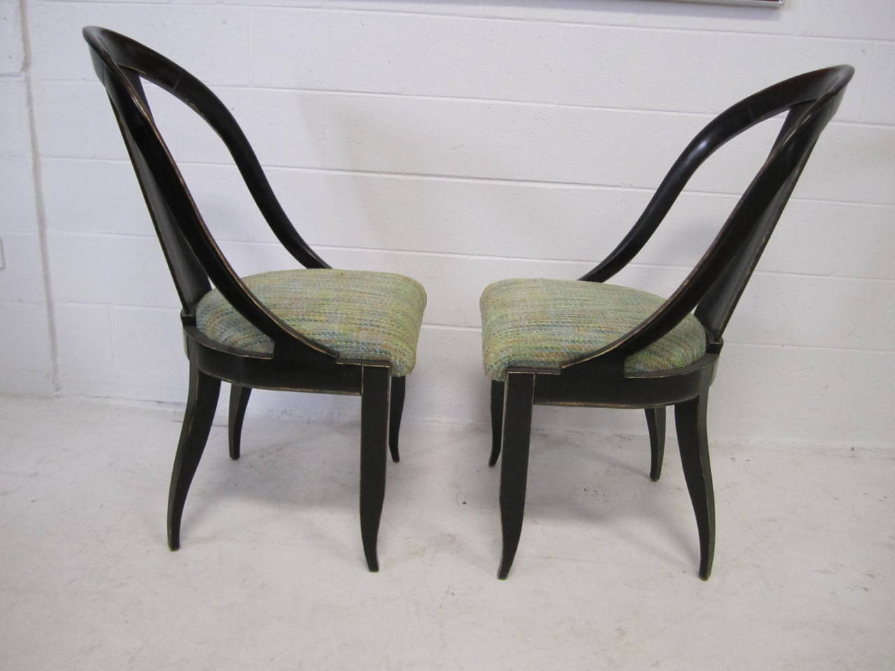Sensuous pair of spoon back side chairs made by Swaim. Gorgeous scale and craftsmanship, these chairs are spectacular in person. The finish is a very dark almost black lacquer with a bit of wood grain showing through. The edges are all antiqued with