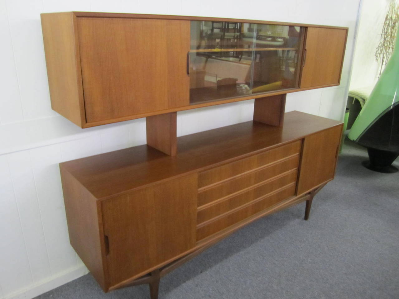 Gorgeous Danish modern teak credenza with floating hutch. This magnificent piece is finished on both sides so it can be used as a room divider. Tons of storage options with sliding doors and drawers. Perfect to divide up an open floor plans into