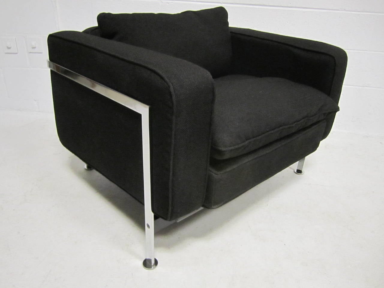 Robert Haussmann pour Steele, chaise longue en tissu et acier.
Haussmann s'inspire de la série LC de LeCorbusier et utilise ici de l'acier massif poli, avec un cadre d'assise en bois et des coussins remplis de duvet.  Le tissu noir épais d'origine