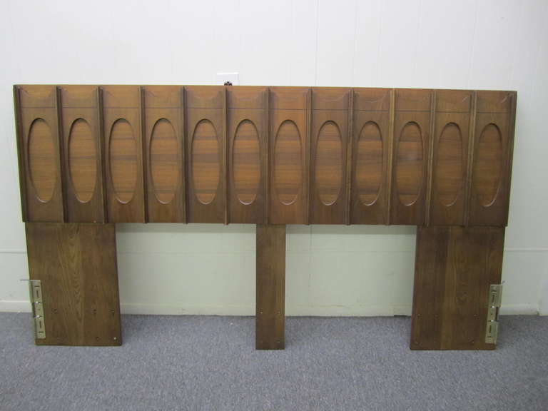 Stunning brutalist style sculptural walnut king size headboard.  Wonderfully carved solid walnut arches and ovals give this piece tons of texture and style. I also have the matching night stands and credenza listed in my other 1stdibs offerings.