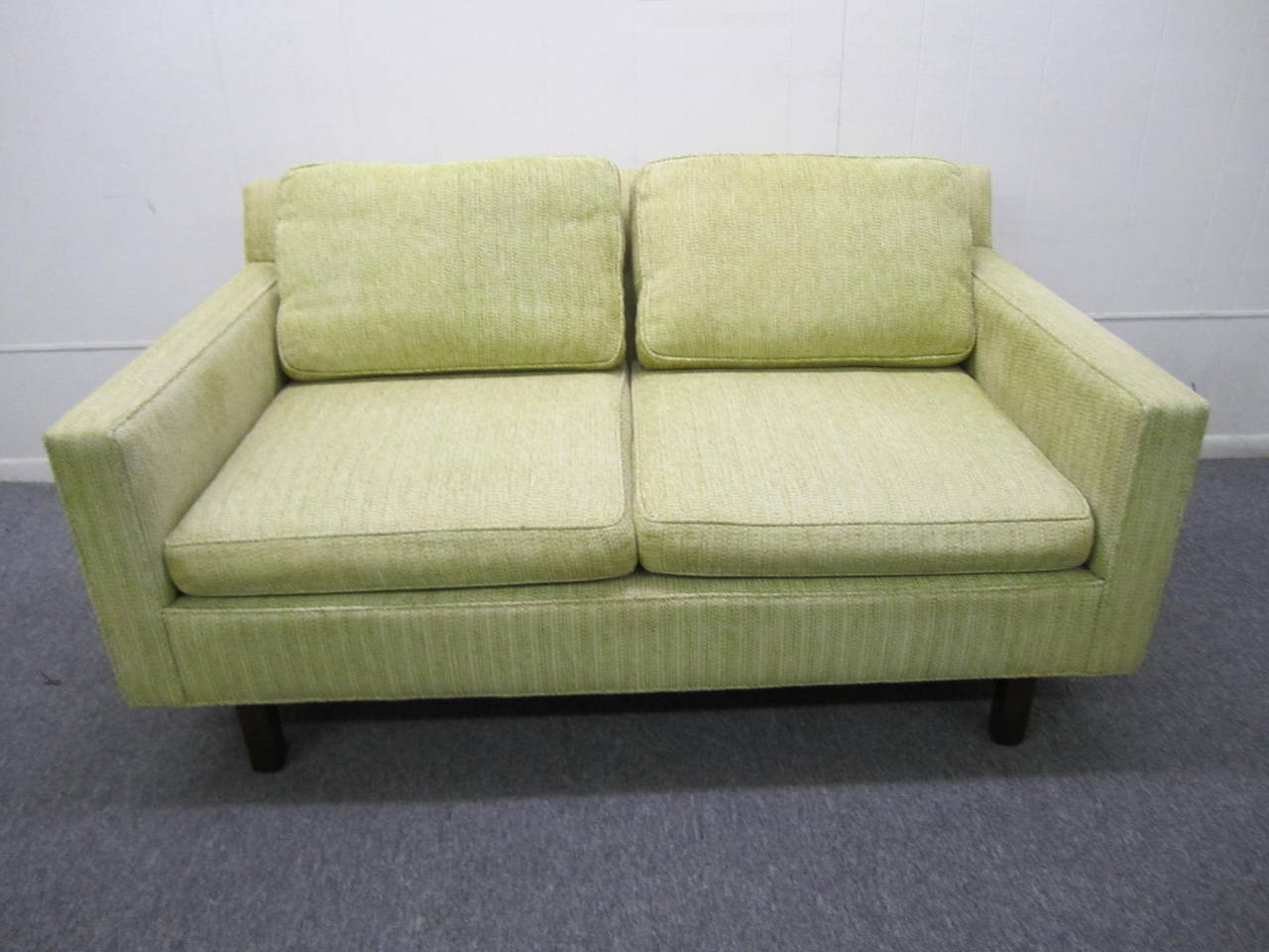 Stunning signed Dunbar 2 seater loveseat sofa. This piece is upholstered in it's original celery green woven wool in very nice to excellent condition. The loose seat cushions are quite firm and will need new foam-the rest of the sofa is quite soft
