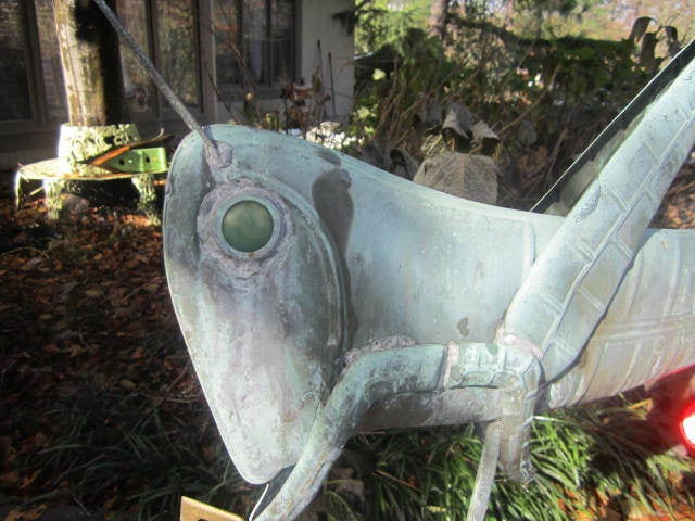 WONDERFUL WHIMSICAL VERDE GREEN COPPER 3-D GRASSHOPPER WEATHER VANE. THE EYE LOOKS TO BE GLASS AND THE COMPASS IS CAST GOLD PAINTED METAL. SEEMS TO HAVE WEATHERED TO A FABULOUS VERDE GREEN PATINA AND IS VERY WELL CRAFTED.  I AM NOT AN EXPERT ON