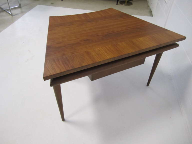 Lovely John Widdicomb trapezoid top walnut end table with one curved drawer.  This table is very rare and well constructed.  The top looks great with a gorgeous finish. I love the curved drawer and floating leg details.