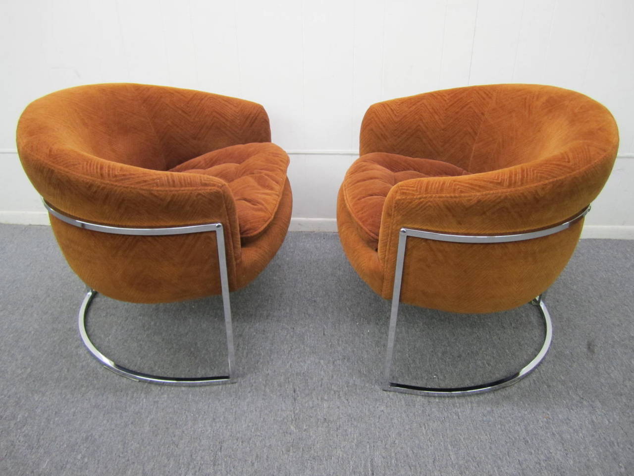 Excellent pair of Milo Baughman thin chrome frame barrel back lounge chairs. These retain their original orange cut velvet upholstery in nice condition. The chrome frames are also in nice vintage condition and are bright and shiny. Really nice as is