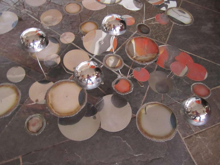 Raindrops, a wall sculpture of punched and torch cut polished chrome discs and domes by Curtis Jere. American, circa 1970. This is the smaller model.