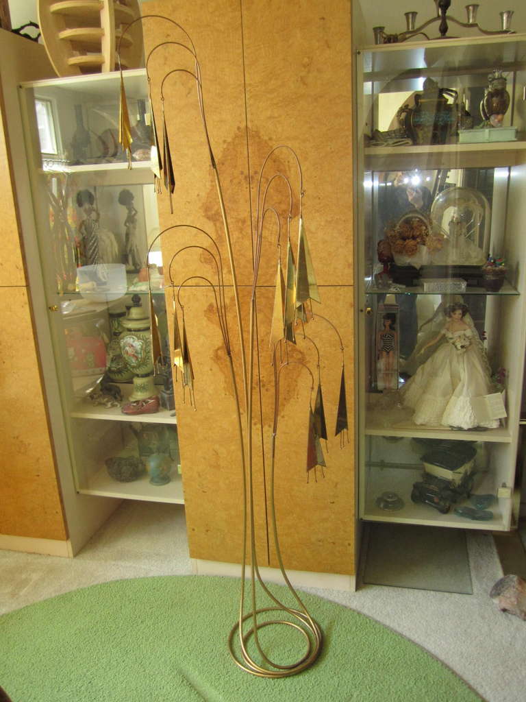 Wonderful signed Curtis Jere brass and copper metal floor sculpture gives a stylized interpretation of a trumpet vine in bloom. The vines are copper the stylized trumpet blossoms are brass. This amazing creation will cast magical shadows on the wall