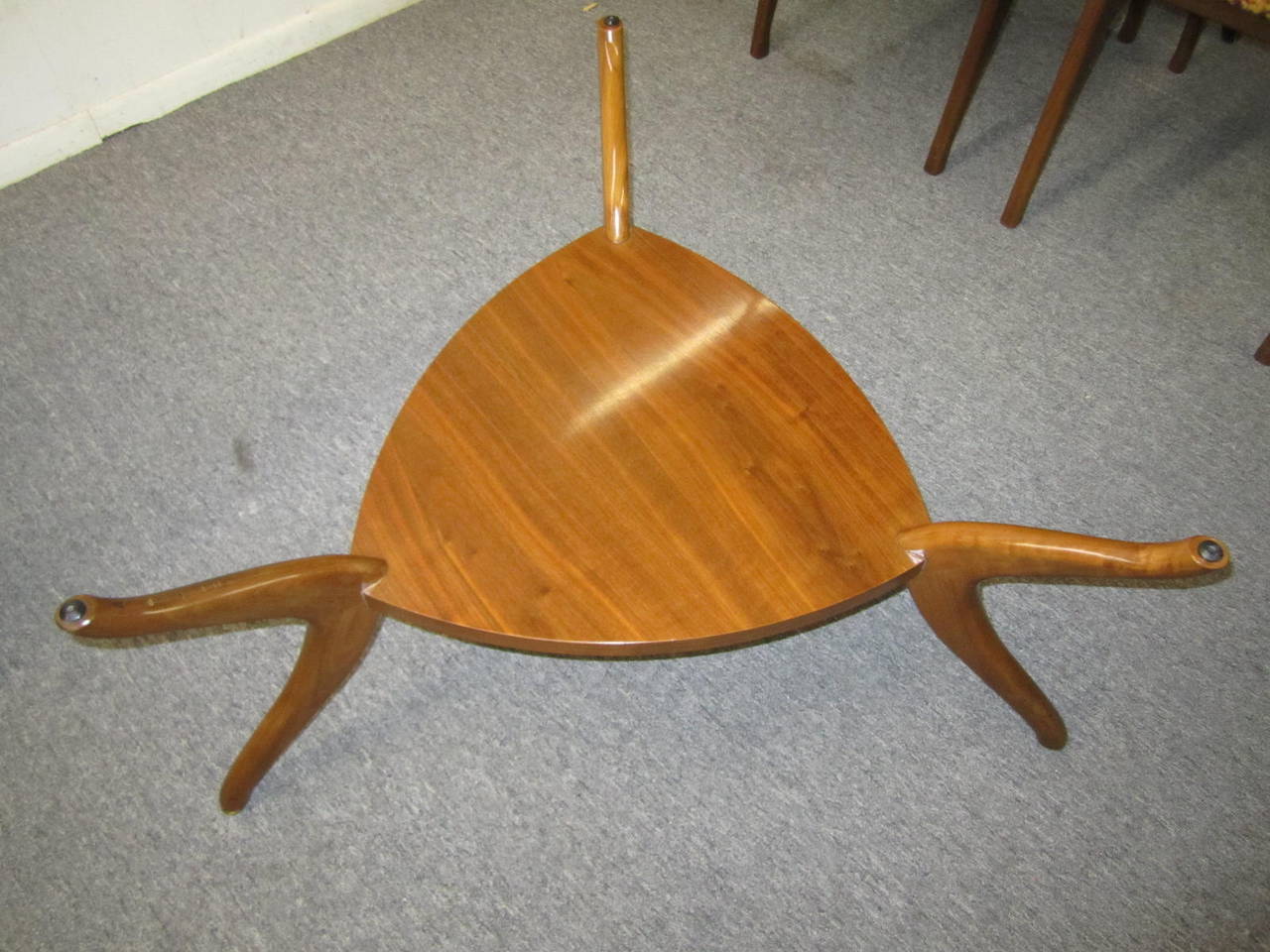 Sculptural walnut triangular coffee table.  3 well carved curved legs hold up a single walnut platform.  The triangular shaped glass looks great on top.