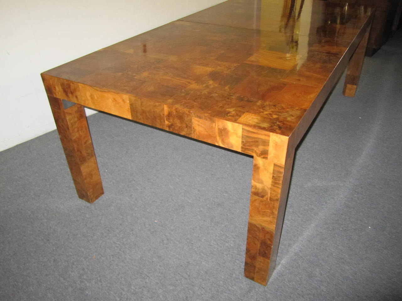 An elegant Paul Evans burl walnut extending dining table, with two leaves. From the 'Citiscape' series, manufactured by Directional, USA, circa 1970, signed by the artist. The two leaves measure 12