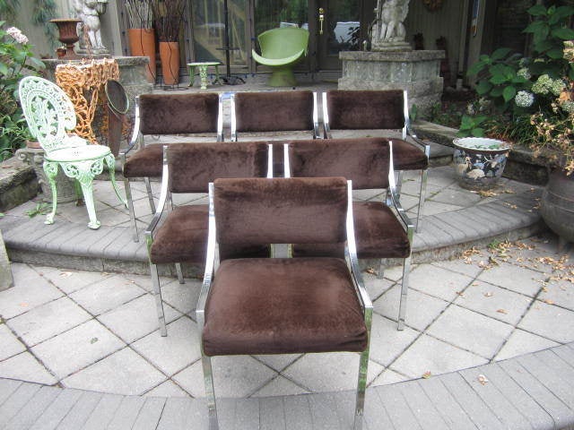 GORGEOUS SET OF 6 MILO BAUGHMAN STYLE CHROME FLATBAR DINING CHAIRS WITH ORIGINAL FABRIC.  THE CHROME LOOKS TO BE IN GREAT VINTAGE CONDITION.  THERE ARE NO LABELS SO I SAY IN THE STYLE OF. ALL OF THE FEET GLIDES ARE PRESENT AND THE FUZZY BROWN FABRIC