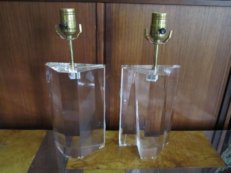 Stunning pair of Prismatic solid lucite lamps.  They are a matched pair in size but one has been faceted adding to their character.  They look like jewelery in person and are quite heavy being made out of solid pieces of lucite.  The cord runs down