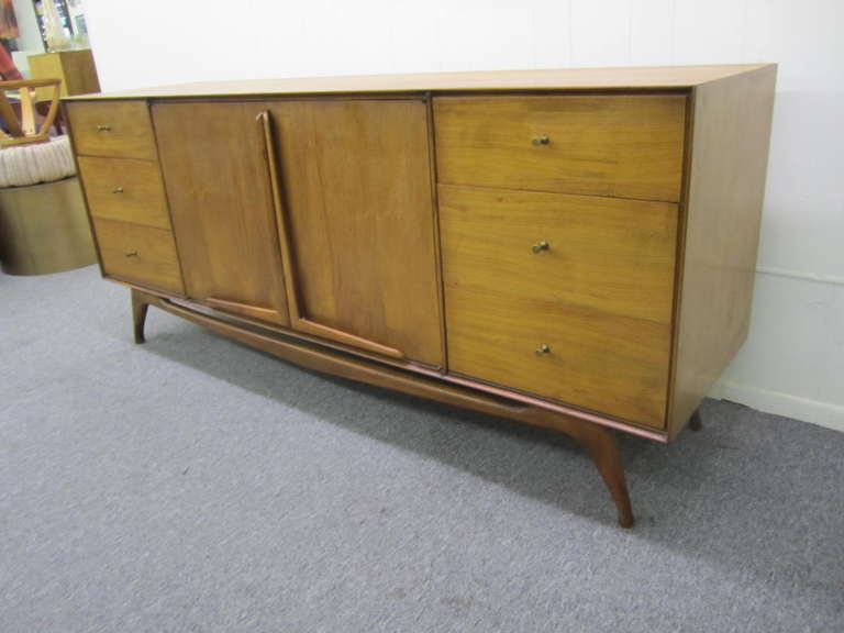 Wonderful Vladimir Kagan style sculptural walnut credenza with splayed legs.  Well crafted with tons of storage-the doors open to reveal a bank of drawers.  I love the sculptued solid walnut pulls on the doors and the lovely splayed legs-very