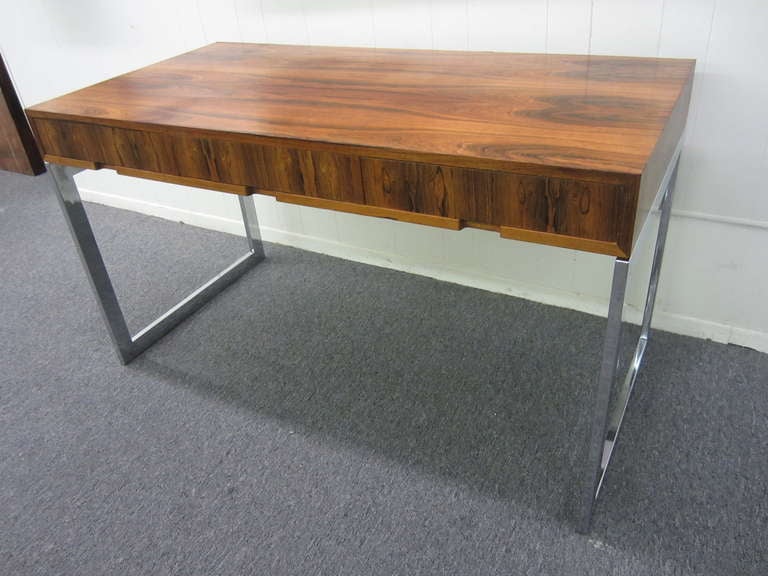 OUTSTANDING MILO BAUGHMAN ROSEWOOD AND CHROME DESK.  WOW!! IS WHAT YOU WILL SAY WHEN YOU SEE THIS PIECE.  THE LEGS HAVE BRILLIANT MIRROR POLISHED CHROMED STEEL.  BRAZILIAN ROSEWOOD TOP HAS LOVELY GRAINING AND THREE HIDDEN DRAWERS.  THIS PIECE LOOKS