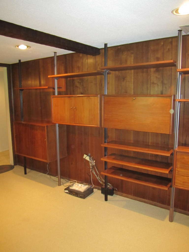 Outstanding 5 bay American mid-century modern walnut wall unit.  I absolutely love the way this set is engineered-brilliant really!  Very easy to put together and tons of storage too.  The rods are very unique- kind of like the aluminum George