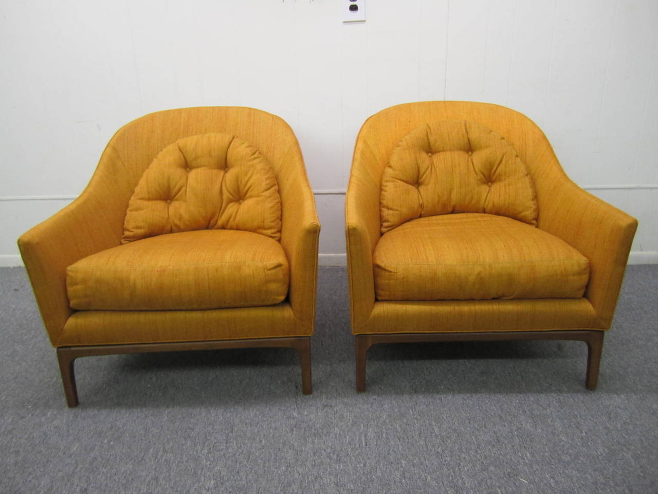 Stunning pair of Harvey Probber style barrel back chairs. Great looking solid walnut bases with flaired back legs. This pair retains it's original orange nubby silk fabric which still looks presentable reupholstery recommended. The bases have both