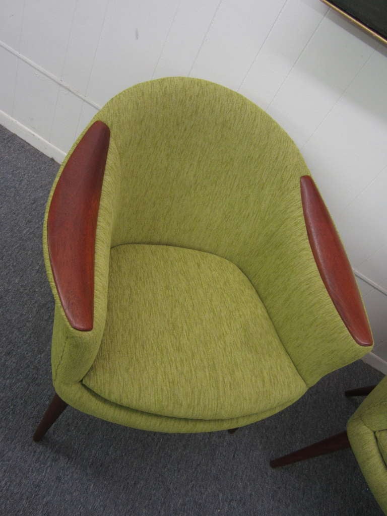Gorgeous pair of apple green pod chairs.  Wonderful swooping teak arms grace these danish modern masterpieces. Newly reupholstered in a Kradvet textured apple green fabric and is to die for.   These chairs also have all new straps and foam making