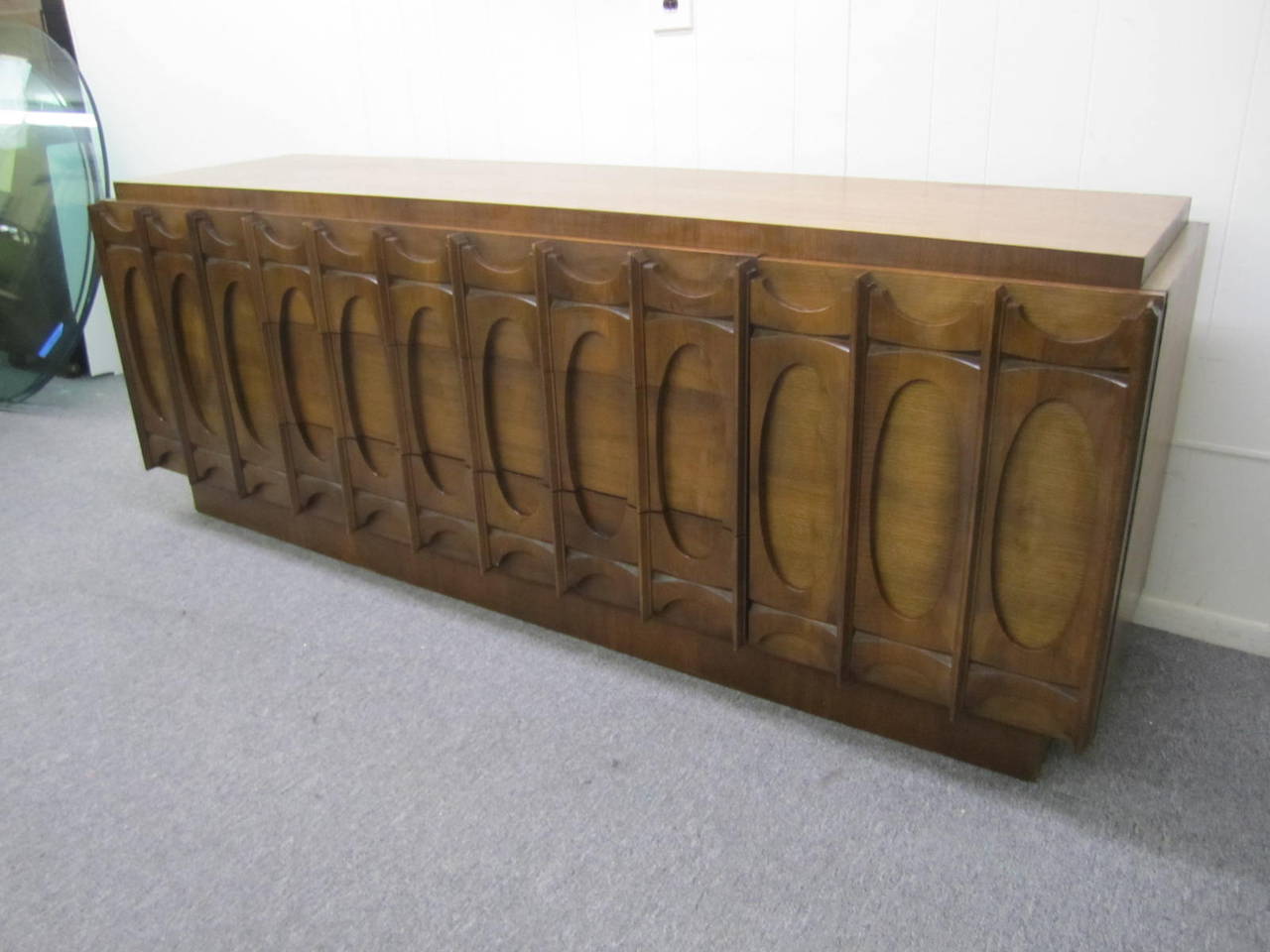 Fantastic Paul Evans inspired Brutalist walnut credenza. Wonderfully carved walnut doors and drawers create a chunky Brutalist look. The doors on either end open to reveal a bank of drawers. Deeper drawers line the center-so there is tons of storage