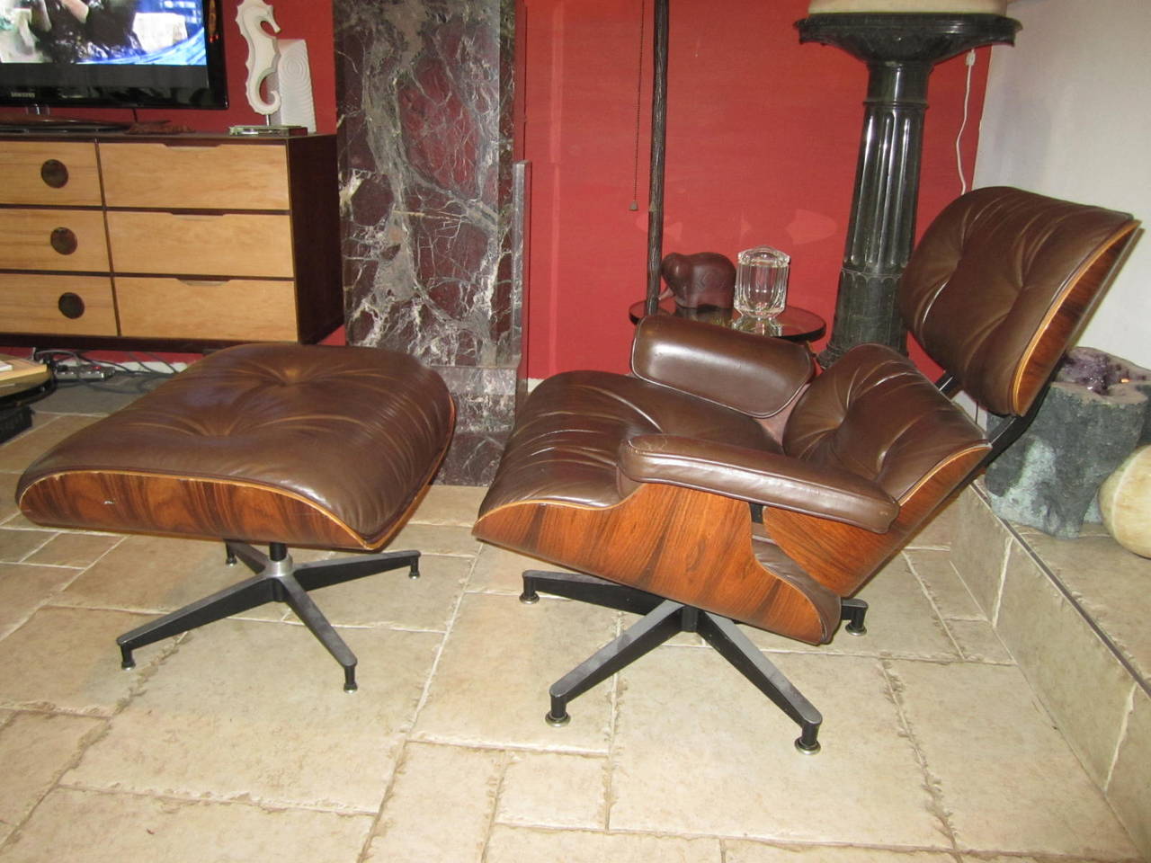 Vintage rosewood lounge chair and ottoman by Charles Eames. This all original example has a beautifully grained rosewood shell, is down filled and upholstered in it's original supple and stunning chocolate brown leather. This chair has wonderful
