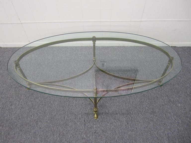 Wonderful solid brass and thick glass hoofed coffee table.  This piece has a lovely vintage patina and is sure to please.