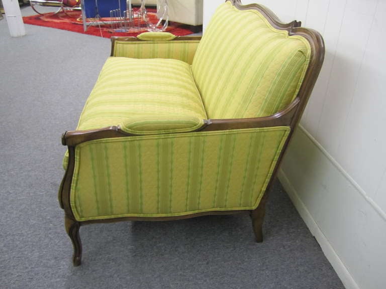 

Super comfortable down-filled French Regency settee. Solid Fruitwood frame with age-related patina.  This piece retains it's original high end Quilted striped fabric in awesome condition. I love the colors with three different shades of