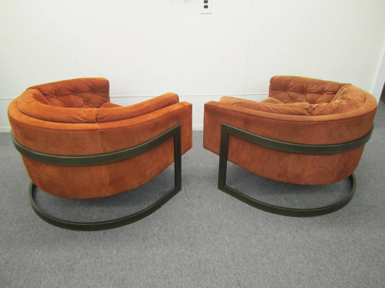 Magnificent pair of Jules Heumann cantilevered bronze frame lounge chair. The chairs retain their original orange suede in nice usable condition, a few small spots. The bronze frames have a fantastic time worn patina-but could be polished for a more