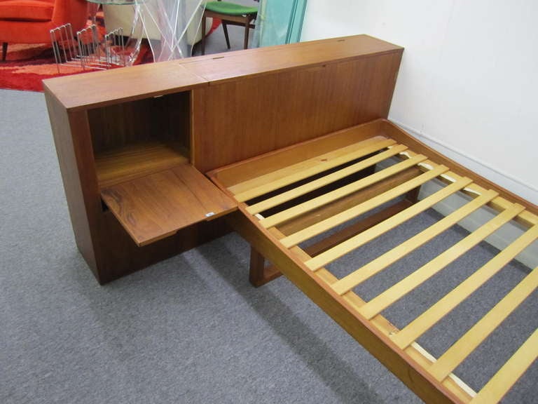 Wonderful 2 piece danish modern teak single bed with head board.  The headboard is a separate piece and has tons of storage space with a flip down night stand and blanket chest.  The bed frame is not attached and has wonderful sculptural legs.  The