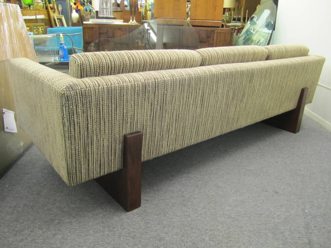 Outstanding and rare signed Harvey Probber tuxedo sofa. This unusual sofa rests on two chunky walnut legs that extend up the back, very handsome! The sofa retains it's original nubby wool fabric in very nice condition. We do have the matching cube