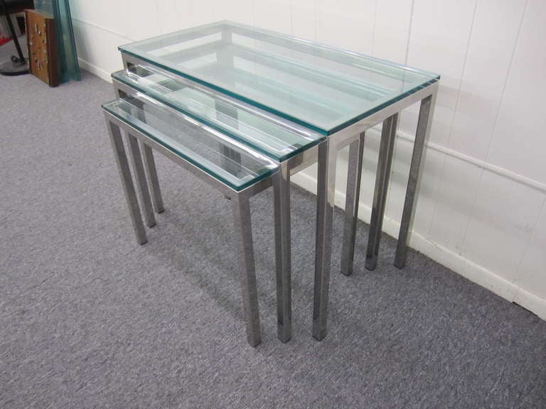 Gorgeous set of 3 Milo Baughman chrome and glass nesting tables.  Heavy chromed table in three graduated sizes.  The largest table measures 22.75