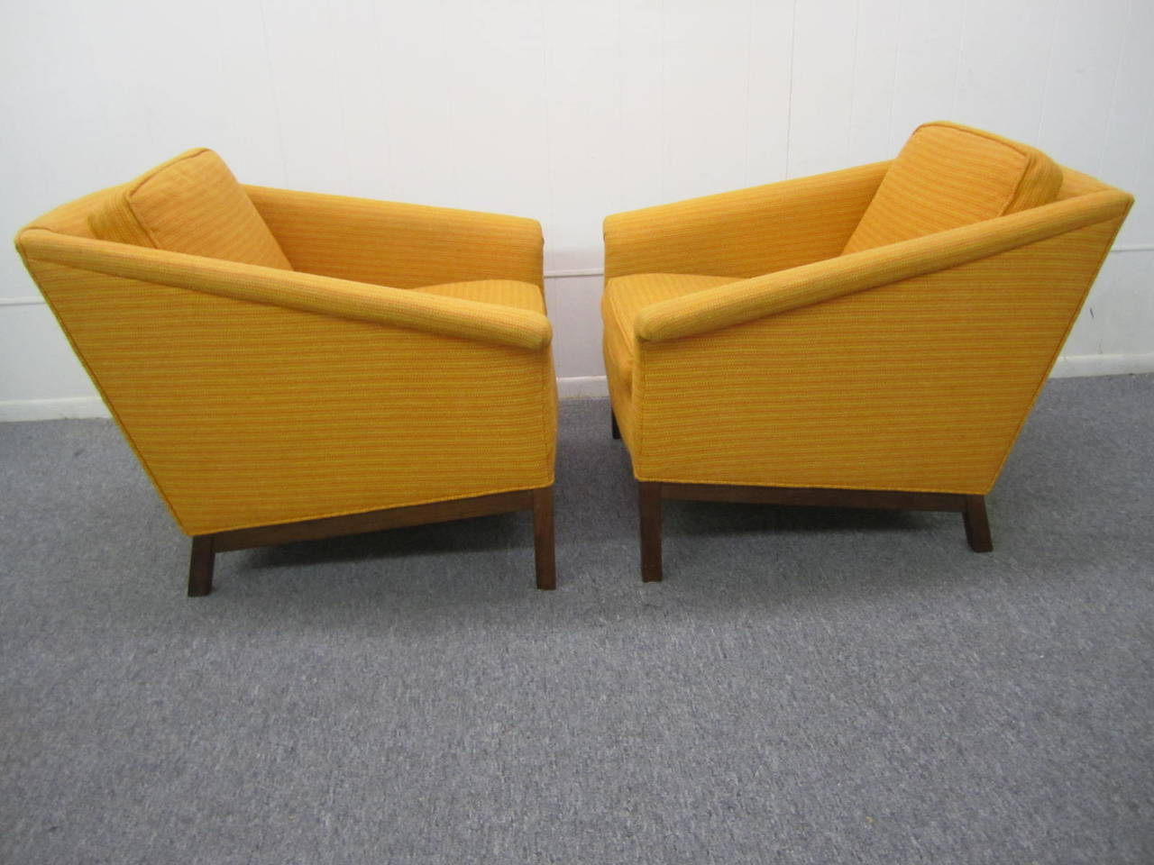 Fantastic angular pair of Probber style lounge chairs. Smart looking walnut legs and base. We love the great looking slanted arms with the angular walnut base- very striking.