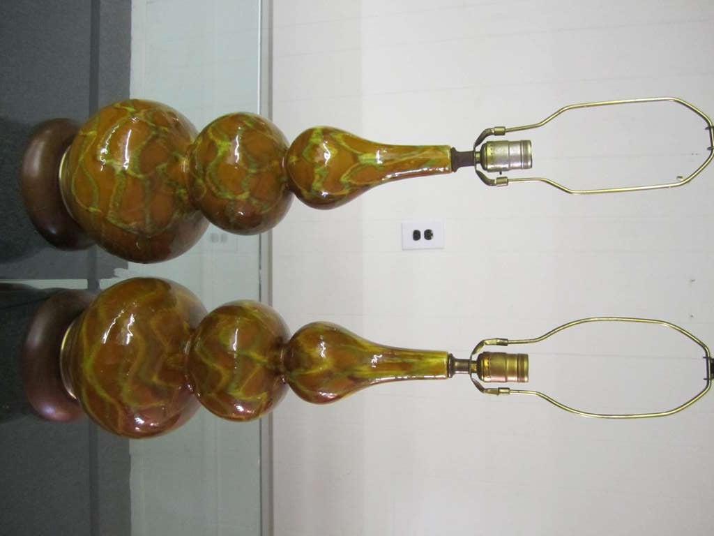 Fabulous pair of bulbous gourd shaped ceramic drip glazed lamps.  Lovely caramel shades of drip glazes with  solid walnut bases.