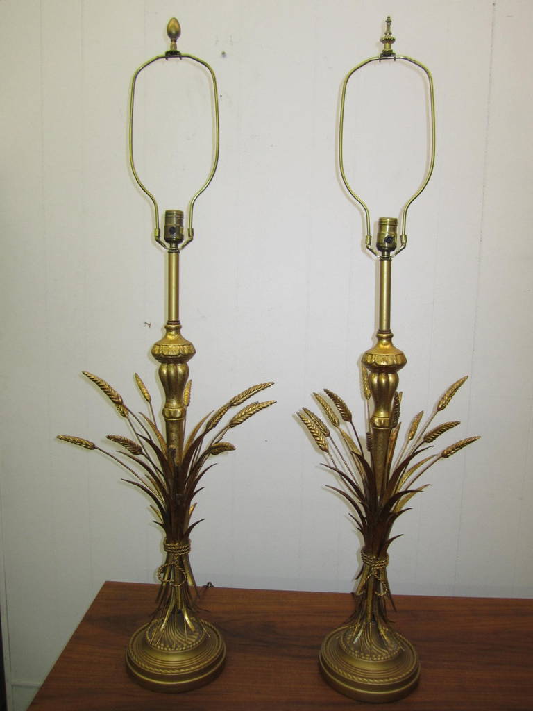 A lovely pair of signed Frederick Cooper metal and wood sheaf-of-wheat table lamps. This pair retain their original barrel shades with lovely gold trim on the top and bottom in fantastic vintage condition. The lamps are 45.5