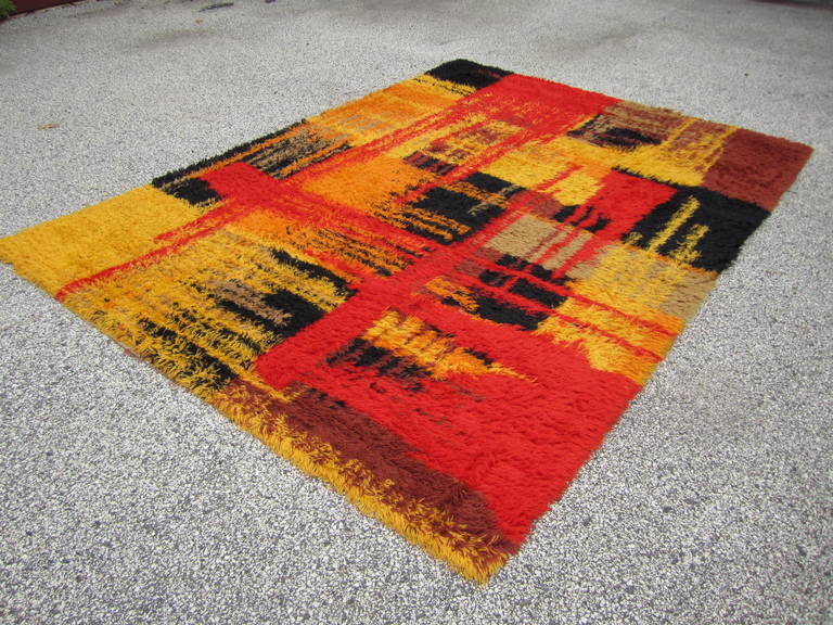 Wonderful large sized Swedish rya rug in wonderful vintage condition.  Fiery warm tones, understated neutrals and crisp jet black background details are juxtaposed in this luxurious vintage Swedish rya. Concentrated hues of persimmon, lemon yellow